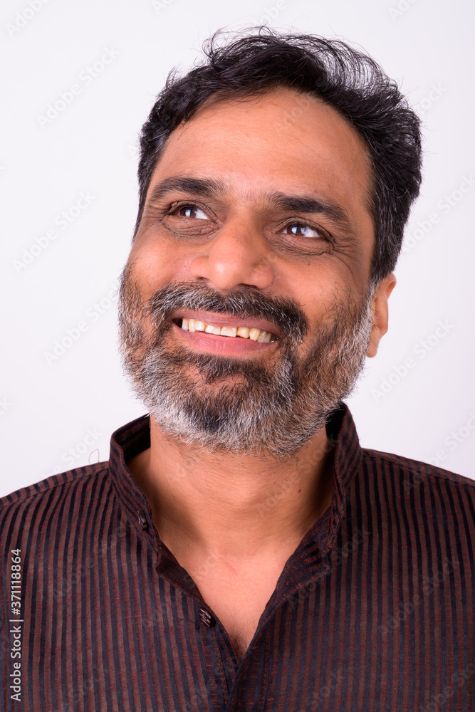 Portrait of happy mature handsome bearded Indian businessman