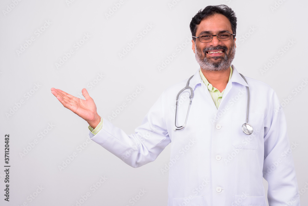 Portrait of happy mature handsome bearded Indian man doctor Portrait of happy mature handsome bearded Indian man doctor