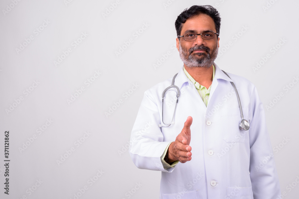 Portrait of mature handsome bearded Indian man doctor