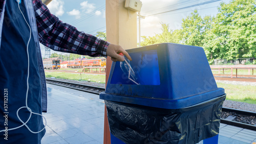 фотографія A young man who throws bottles into trash in a train station in Chiang Mai, Thailand