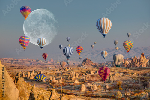 Hot air balloon flying over spectacular Cappadocia with full moon "Elements of this image furnished by NASA"