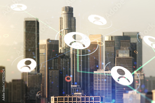 Double exposure of social network icons hologram on Los Angeles office buildings background. Networking concept
