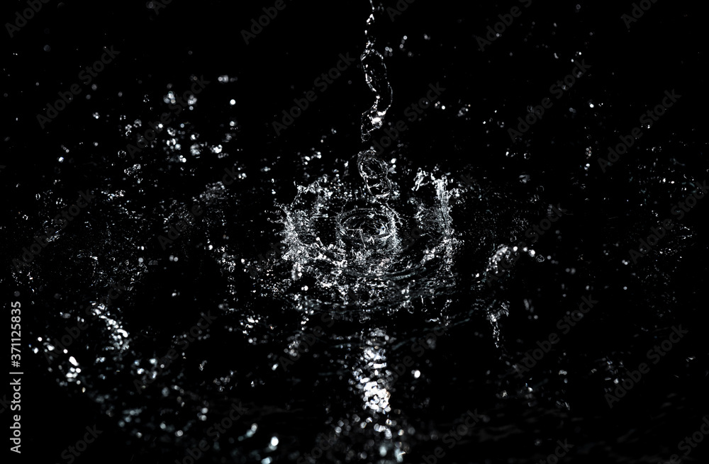 Splashes and drops of water are on a black background. Splashes and drops of water are on a black background.
