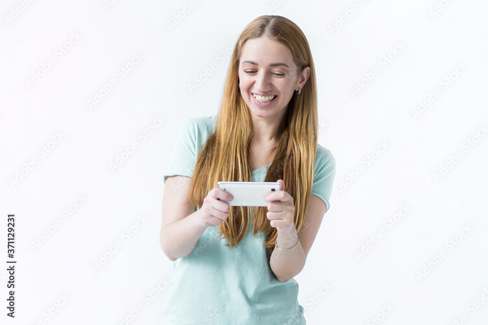 girl playing fascinating mobile game, holding smartphone horizontally, smiling amused athe and entertained, found perfect app for leisure relaxing time, white background girl playing fascinating mobile game, holding smartphone horizontally, smiling amused athe and entertained, found perfect app for leisure relaxing time, white background