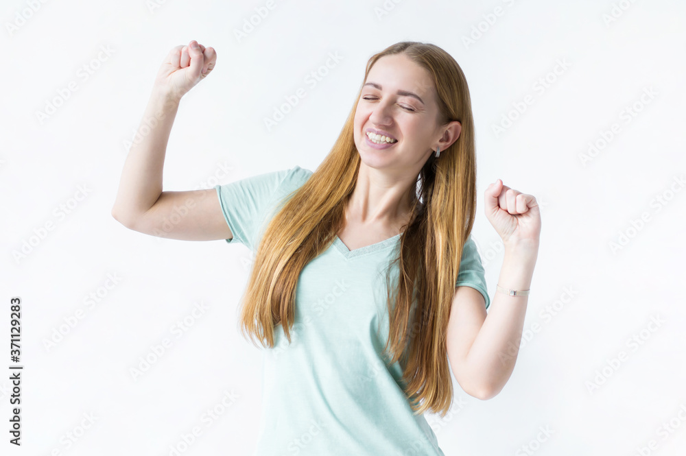 Portrait of a girl, she is happy, clenched her hands into fists and raised them up. Photo on white background Portrait of a girl, she is happy, clenched her hands into fists and raised them up. Photo on white background