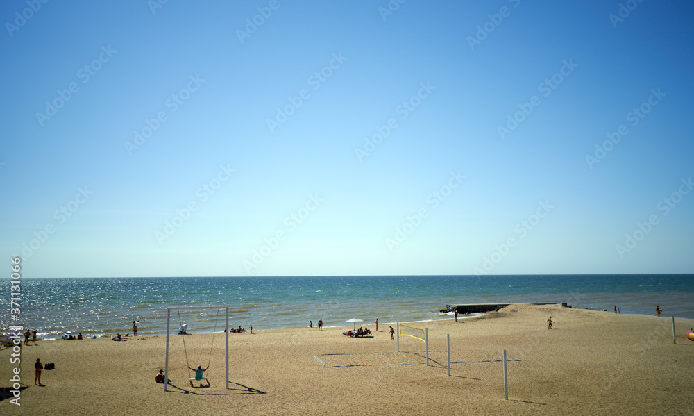 people sunbathe by the sea