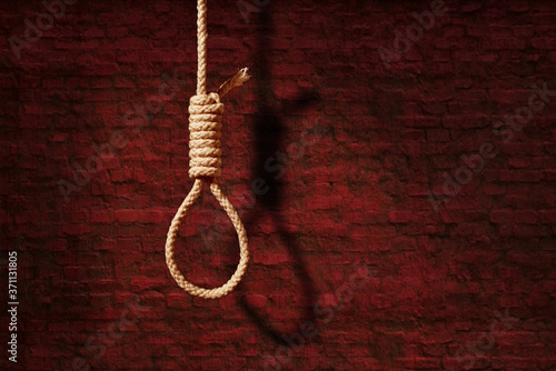 suicide concept. noose with shadow on dark wall background