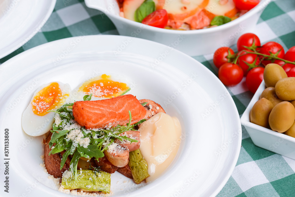 Meat with boiled eggs, lasagna, puff pastry strawberry dessert served on the table. Italian cousine concept. Meat with boiled eggs, lasagna, puff pastry strawberry dessert served on the table. Italian cousine concept.