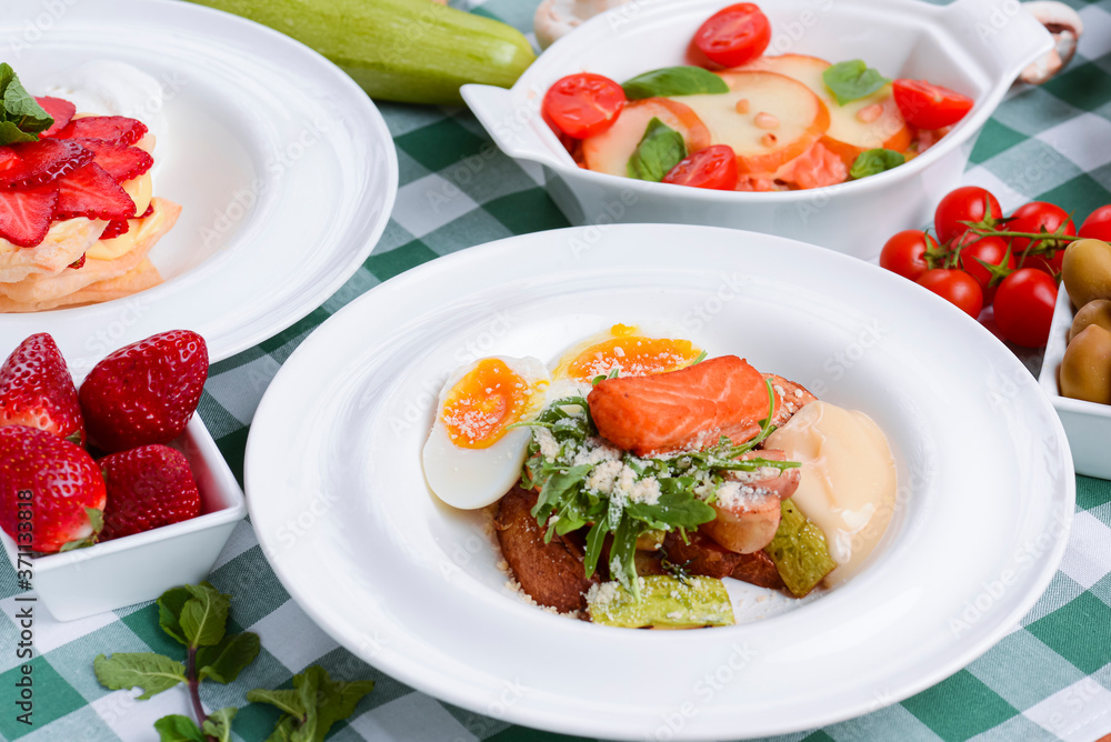 Meat with boiled eggs, lasagna, puff pastry strawberry dessert served on the table. Italian cousine concept. Meat with boiled eggs, lasagna, puff pastry strawberry dessert served on the table. Italian cousine concept.