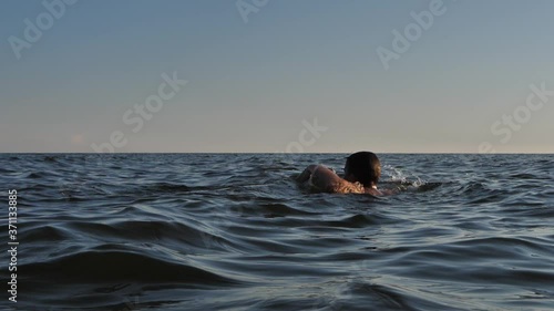 The boy drowning in the sea with his hands showing help