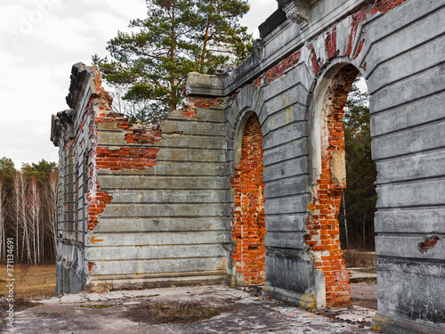 The ruins of an ancient castle Tereshchenko Grod in Zhitomir, Ukraine. In the background blue sky, on the earth grows green grass. Palace of the 19th century photo