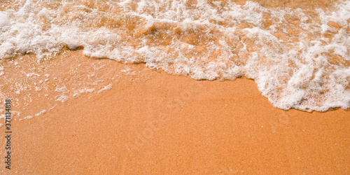 Tourist travel banner design template, copy space. White foam of a sea wave, golden sand beach, turquoise ocean water.