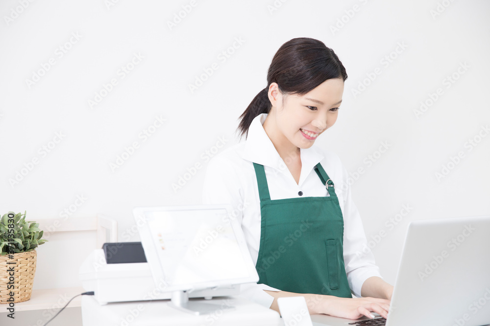 パソコンを操作する女性店員