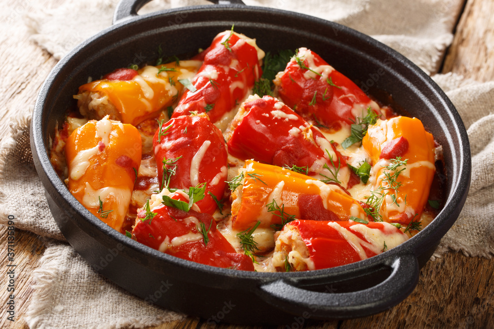 Hot baked stuffed peppers with tomato sauce close-up in a frying pan on the table. horizontal Hot baked stuffed peppers with tomato sauce close-up in a frying pan on the table. horizontal