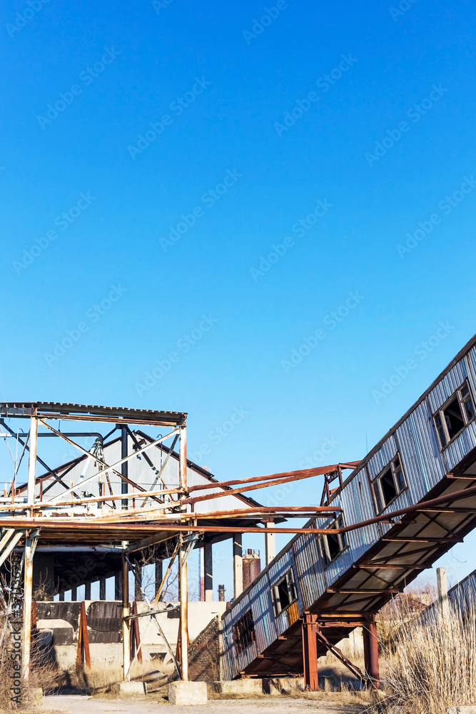 Old, abandoned concrete plant with iron rusty tanks and metal structures. The crisis, the fall of the economy, stop production capacity led to the collapse. Global catastrophe.