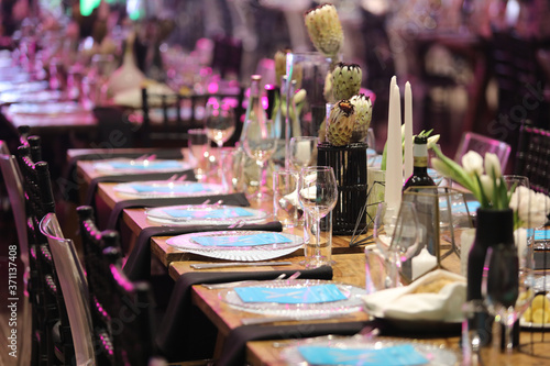 Gala dinner setup with white flowers and blue place cards. photo