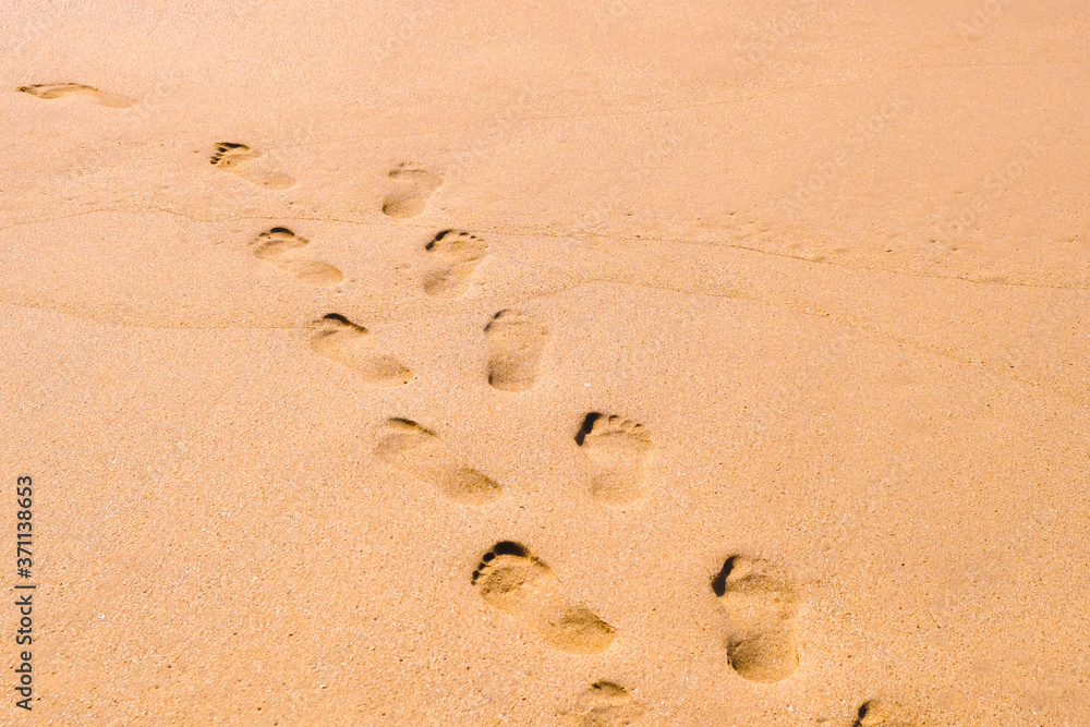 Human footprints leading away from the viewer into the sea. Empty beach, tourism concept, travelling. Human footprints leading away from the viewer into the sea. Empty beach, tourism concept, travelling.