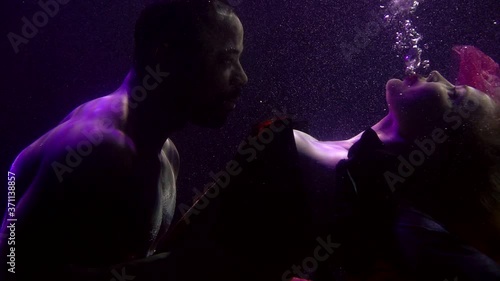 sexy lady and handsome man are having preliminary caress underwater, romantic date