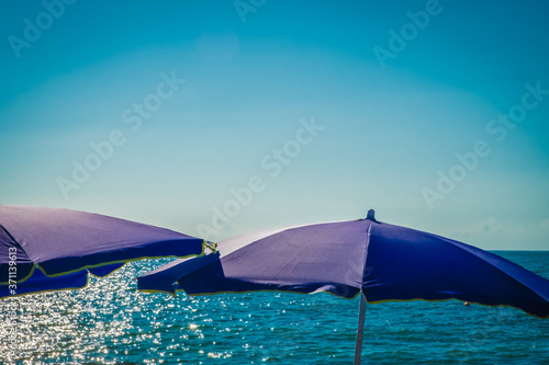 Beach umbrella by the sea. Sunset on the beach. A colorful, large awning to protect from the sun's rays. Summer. Day. Georgia. Black Sea.