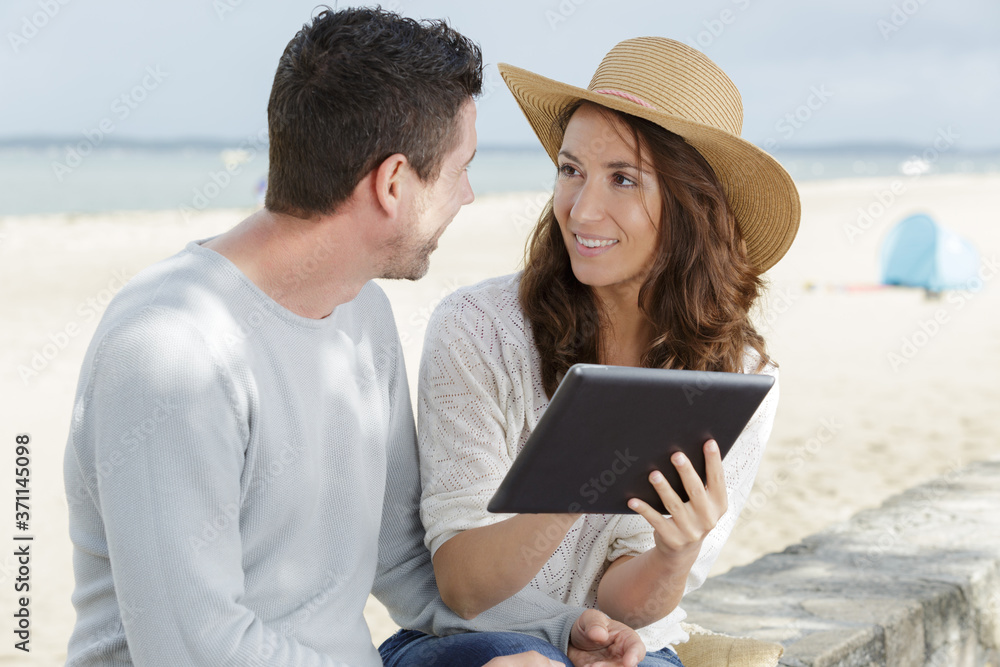 man and woman with a tablet outdoors