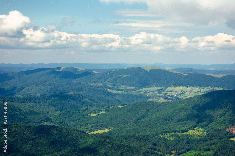 Fototapeta premium mountain landscape on a summer day. hills rolling from the valley up in to the distant ridge. view of the wonderful outdoor scenery beneath a sky with clouds