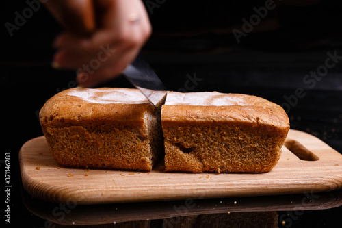 Homemade gray bread on a black background. Photo in section.