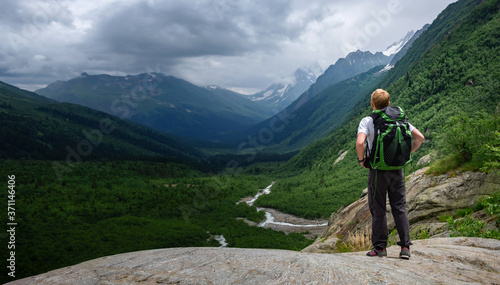Man hiking at mountains with heavy backpack.