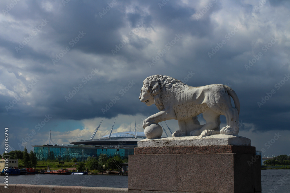 History and modernity - a white lion statue and a modern stadium that looks like a flying saucer. St. Petersburg. History and modernity - a white lion statue and a modern stadium that looks like a flying saucer. St. Petersburg.