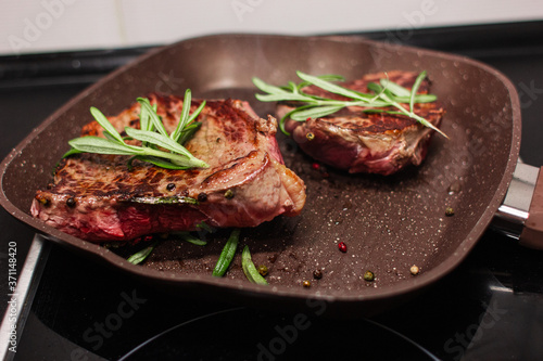 grilled beef steak with vegetables, seasoned with pepper and rosemary, close-up