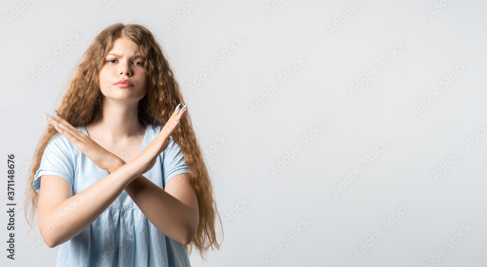 Young woman shows a STOP gesture on white background Young woman shows a STOP gesture on white background