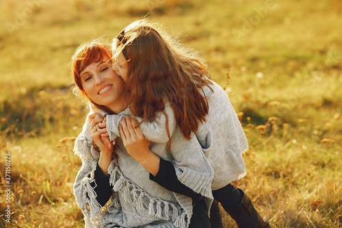 Photo Family in a autumn field. Mother with red hair. Cute little girl