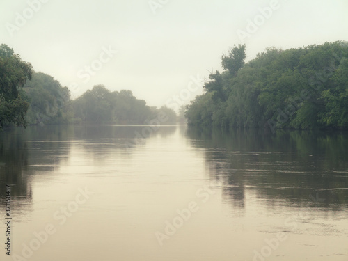 Beautiful authentic river landscape in light morning haze