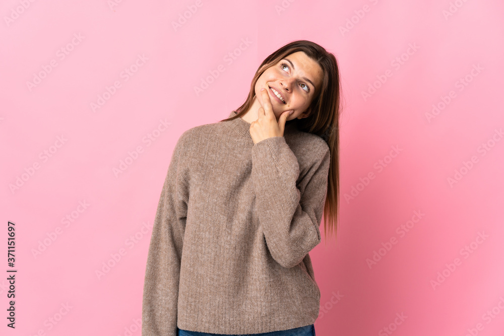 Young slovak woman isolated on pink background looking up while smiling Young slovak woman isolated on pink background looking up while smiling
