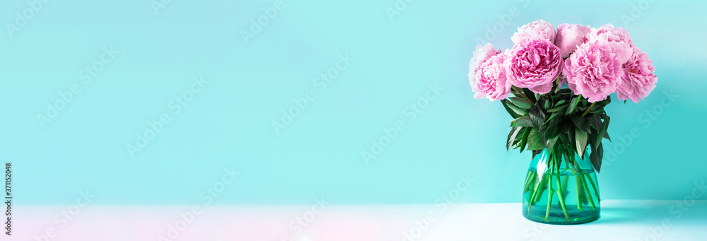 Pink peonies bouquet in vase on blue background with copy space. Floral composition. Wedding, birthday, anniversary bouquet. Woman day, Mother's day. Macro of peonies flowers. Pink peony flower Pink peonies bouquet in vase on blue background with copy space. Floral composition. Wedding, birthday, anniversary bouquet. Woman day, Mother's day. Macro of peonies flowers. Pink peony flower