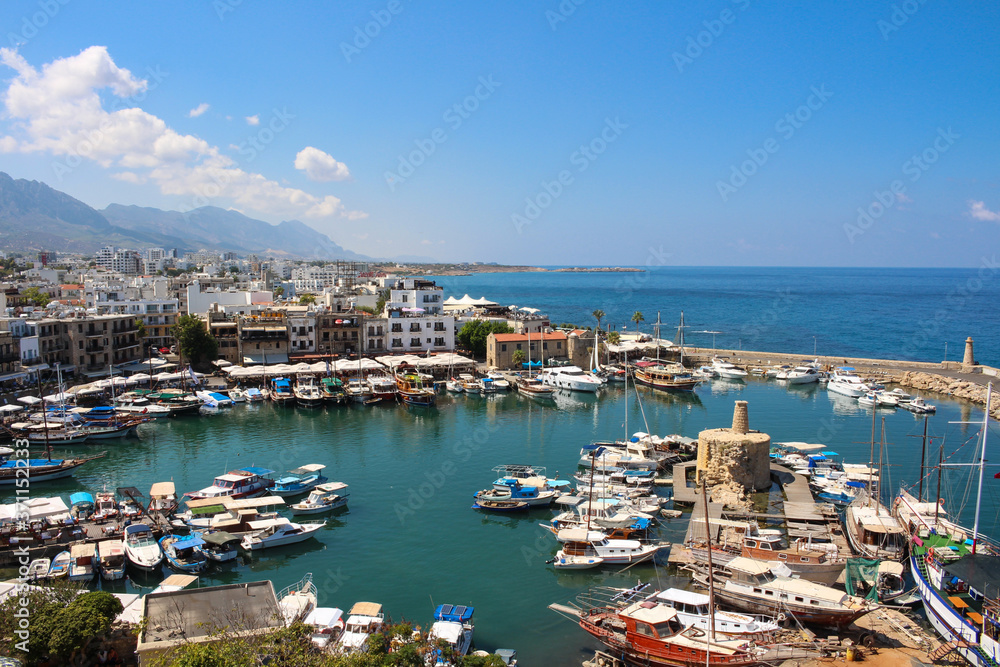  Kyrenia harbour in the shape of a horseshoe and old houses around it. Many boats and yachts.