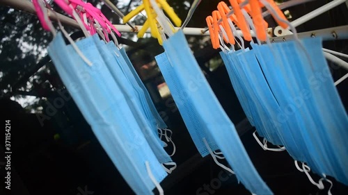 Video footage of reusable masks hanging on a stand with clips plugged . corona virus pandemic masks