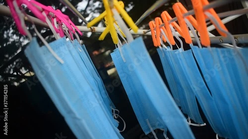 Video footage of reusable masks hanging on a stand with clips plugged . corona virus pandemic masks
