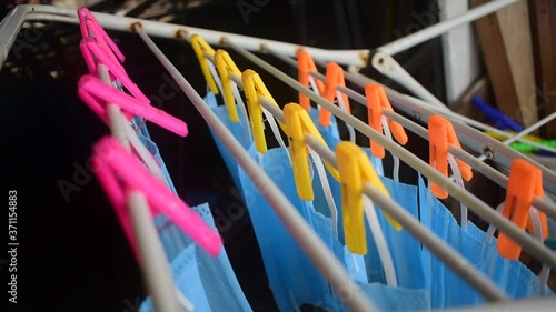 Video footage of reusable masks hanging on a stand with clips plugged . corona virus pandemic masks