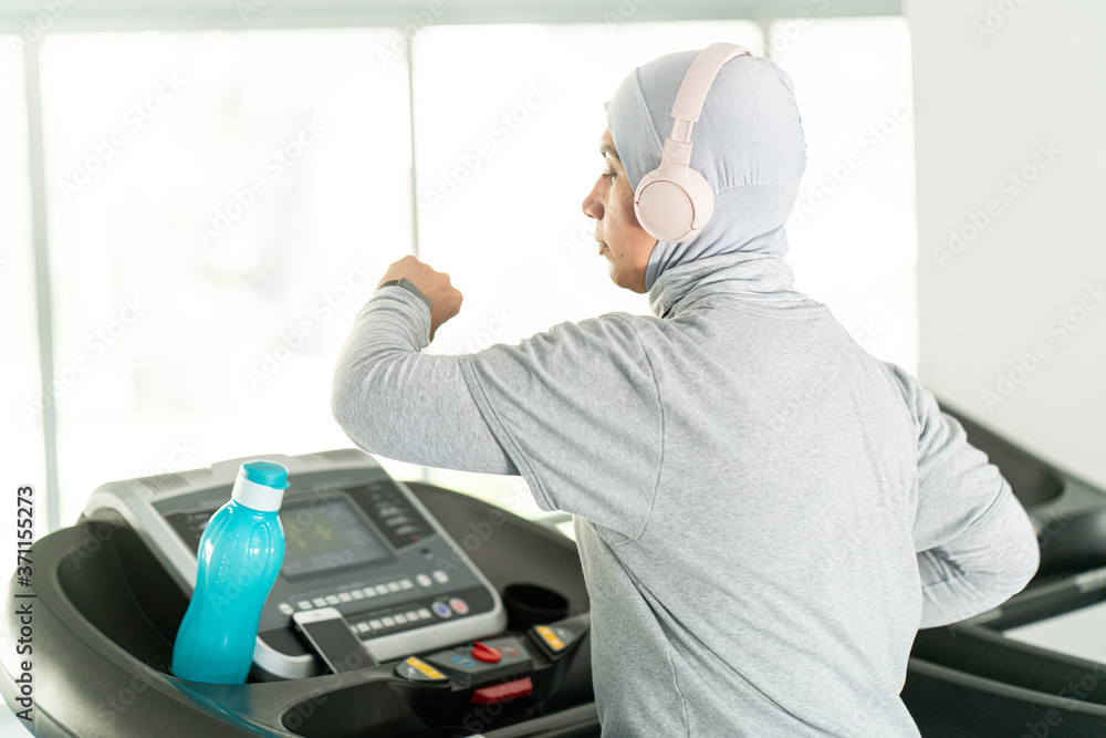 Muslim Adult Woman with Headphones on Treadmill