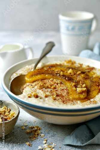 Delicious oat porridge with caramelized banana and nuts for a breakfast.