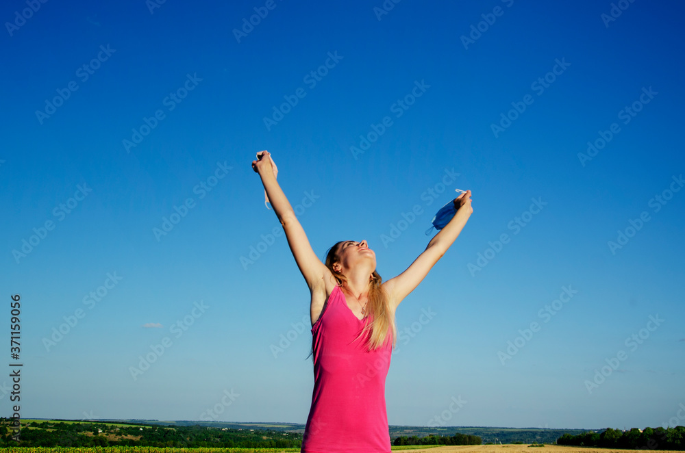 Freedom of people from wearing medical masks and social distance. End of quarantine and general removal of masks. Joyful girl throws up the mask against the blue sky Freedom of people from wearing medical masks and social distance. End of quarantine and general removal of masks. Joyful girl throws up the mask against the blue sky