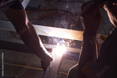 Unsafe Welder Working with no Protection Uniform, Weld Metal with Arc Welding Machine in the Construction Site.