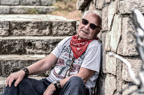 Old man on a motorcycle in the mountains