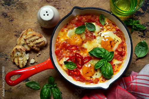 Shakshouka - traditional dish of israeli cuisine from tomatoes and eggs. Top view with copy space. photo