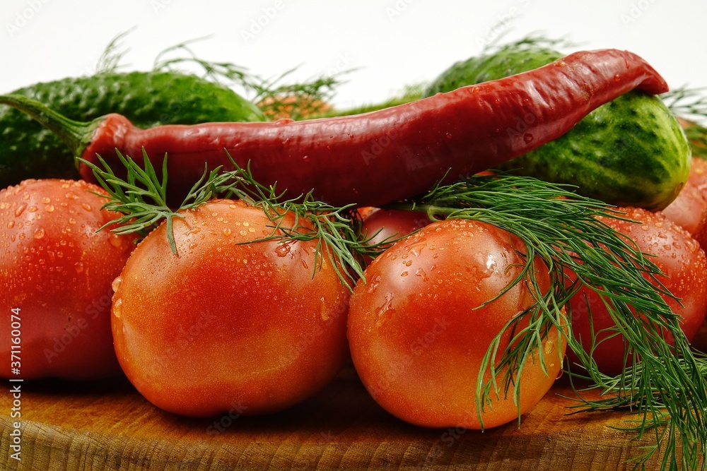 Green dill, cucumbers, chili peppers and tomatoes lie on a wooden board Green dill, cucumbers, chili peppers and tomatoes lie on a wooden board
