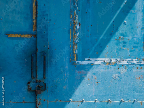 青く塗装された錆びた鉄の扉 © 正人 竹内