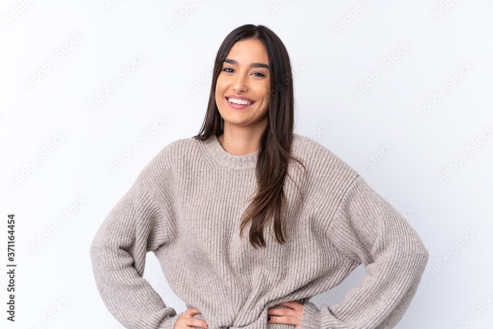 Young brunette woman over isolated white background posing with arms at hip and smiling Young brunette woman over isolated white background posing with arms at hip and smiling