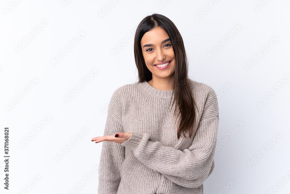 Young brunette woman over isolated white background presenting an idea while looking smiling towards Young brunette woman over isolated white background presenting an idea while looking smiling towards