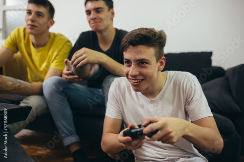 teenager boy playing games on console at home