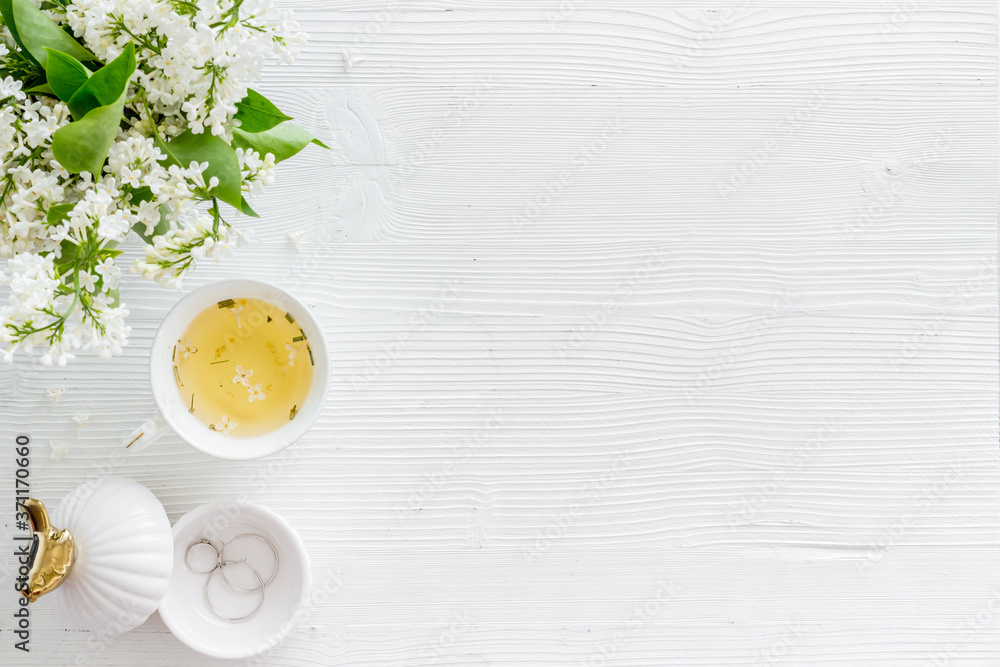 Flat lay of jasmine flowers bouquet with cup tea on workspace Flat lay of jasmine flowers bouquet with cup tea on workspace
